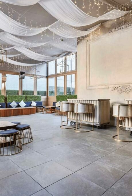 Salle de réception avec plafonds drapés, luminaires et mobilier élégant