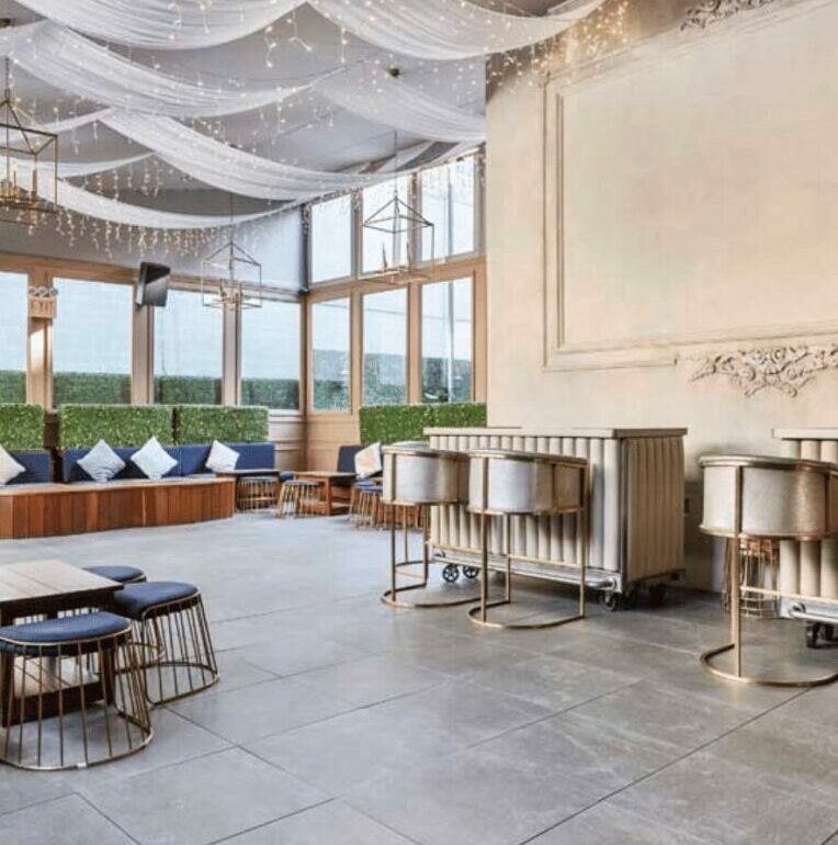 Salle de réception avec plafonds drapés, luminaires et mobilier élégant