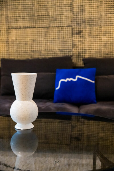 détail sur un vase déco avec un coussin bleu pour airbnb location