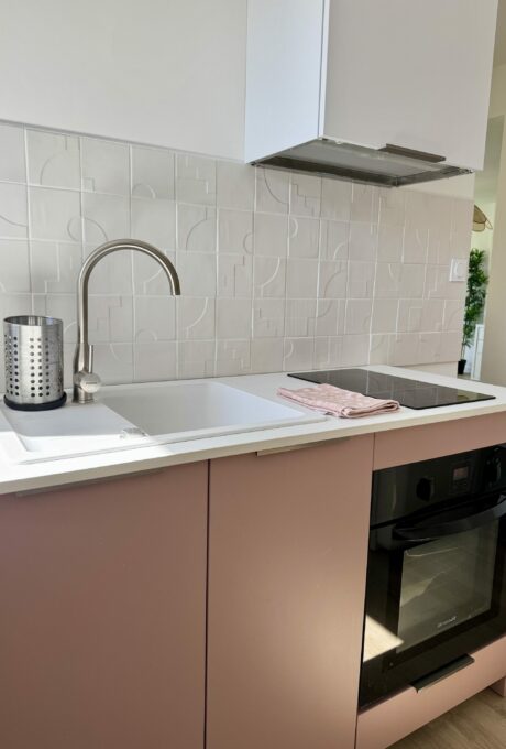 Cuisine moderne avec évier, robinet, plaque de cuisson, four, dosseret blanc, armoires roses, architecte intérieur toulouse