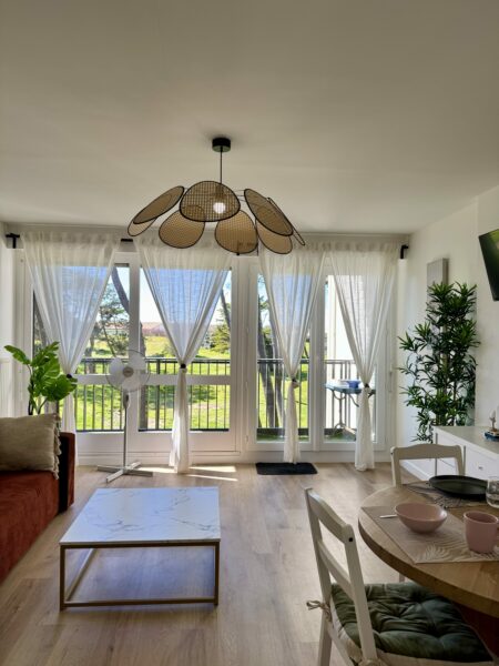 Salle à manger moderne avec éclairage unique, plantes, et mobilier stylé.