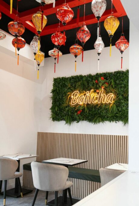 Intérieur de restaurant avec lanternes colorées suspendues et mur végétal