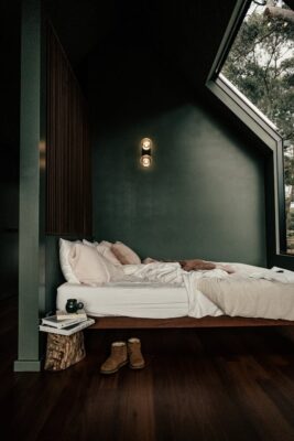 chambre verte avec lit tourné vers l'extérieur