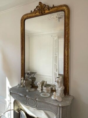 miroir ancien doré sur une cheminée en marbre