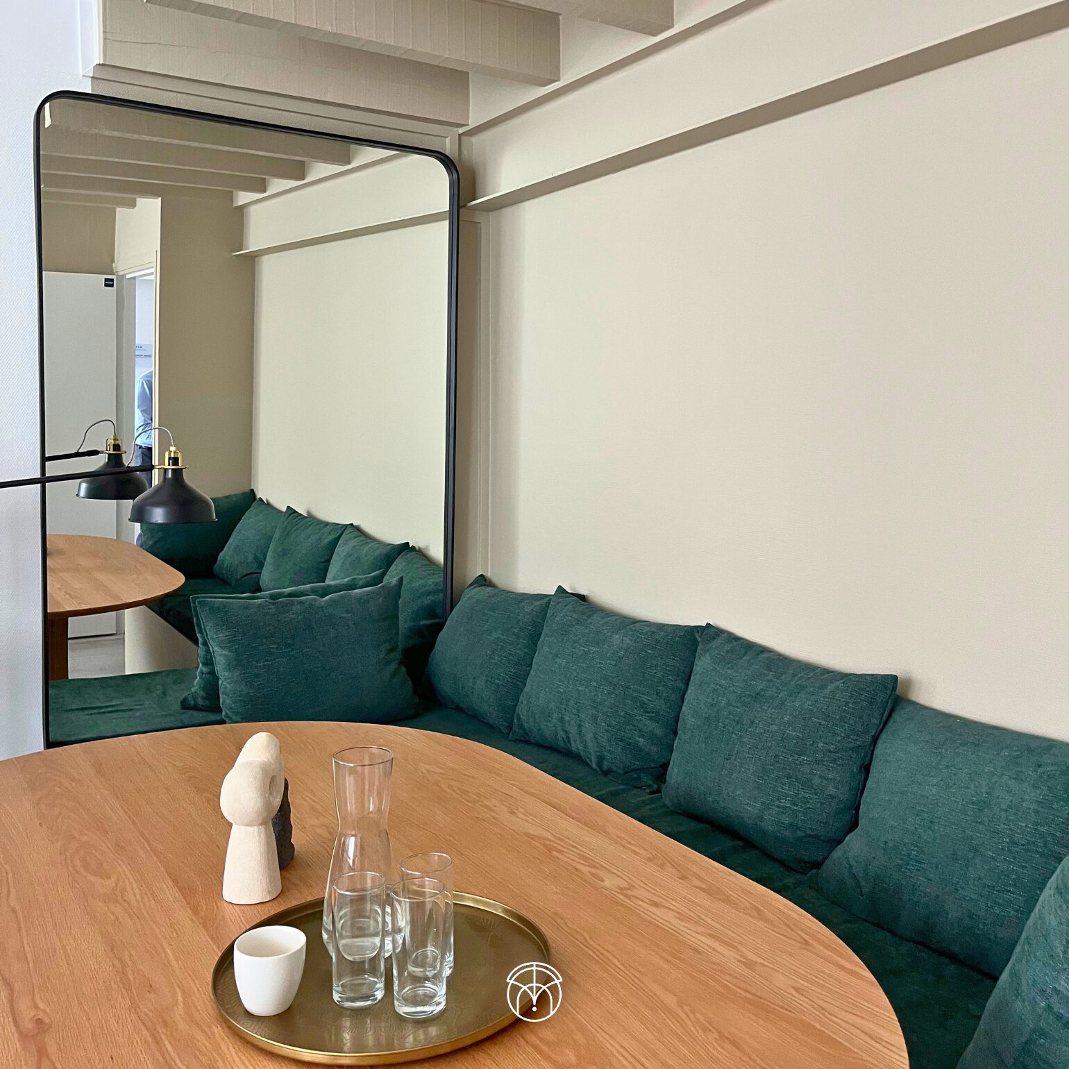 Salon moderne avec canapé vert et table basse en bois.