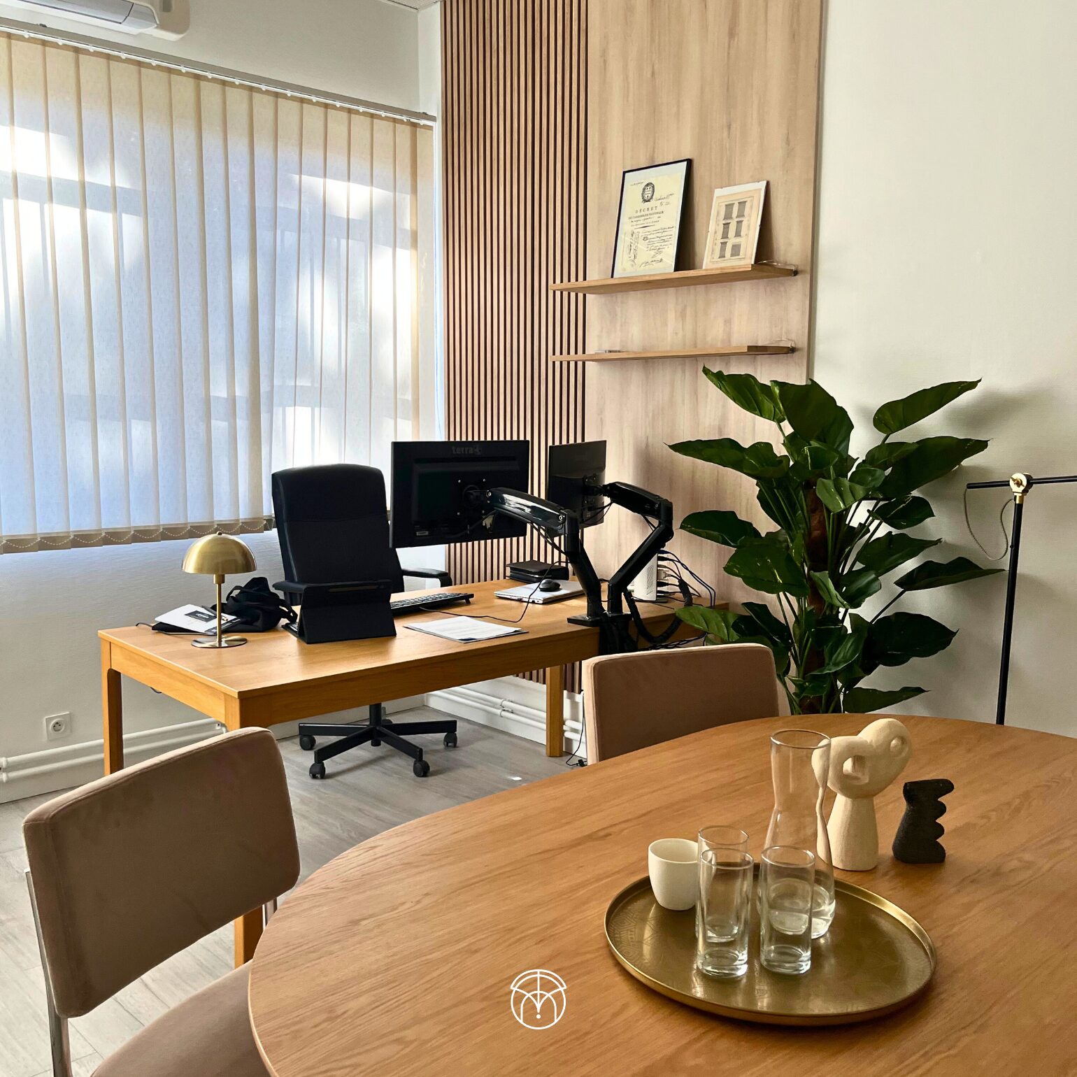 Bureau moderne avec table en bois, plantes et décorations.