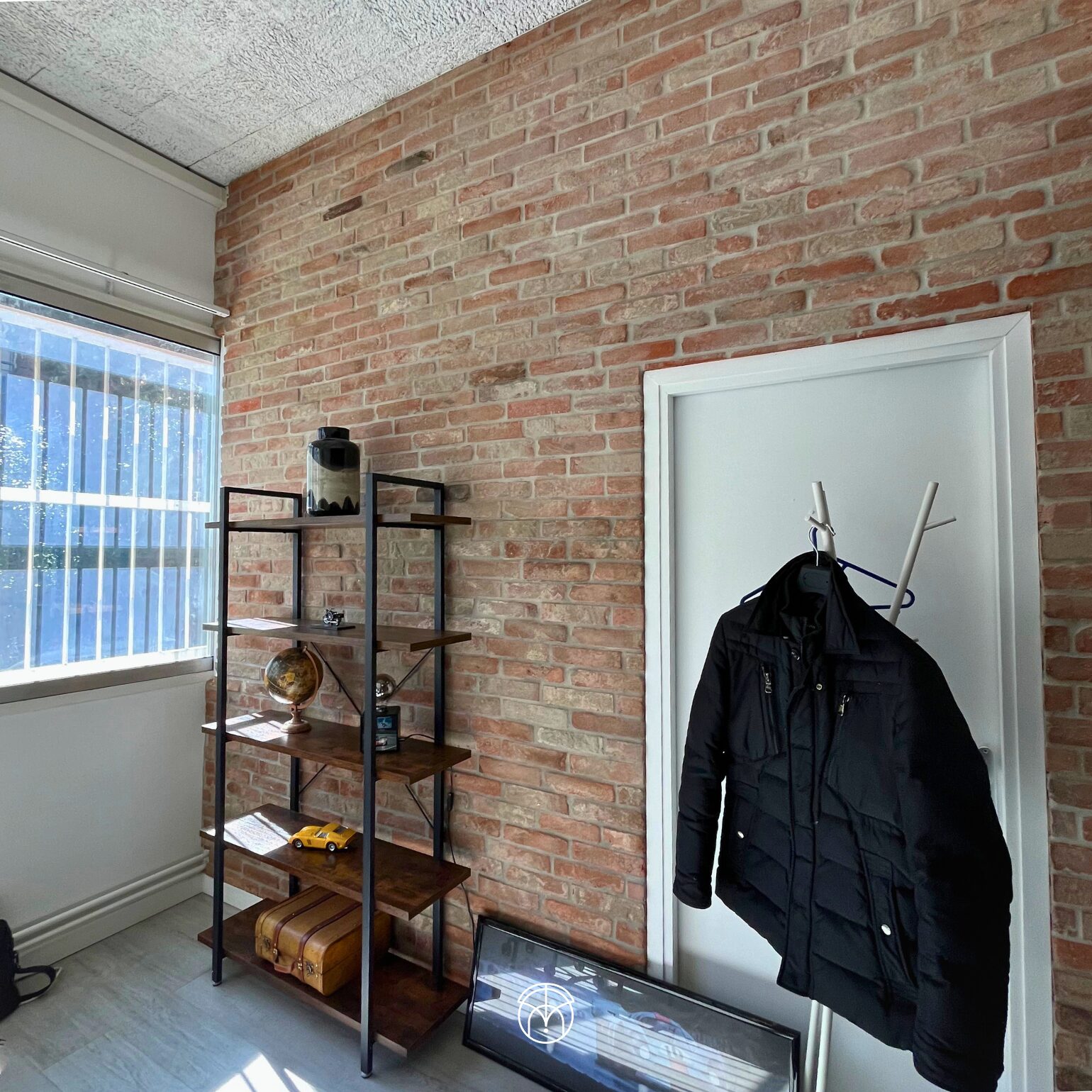 Intérieur moderne avec brique, étagère, manteau sur porte, architecte intérieur toulouse