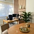 Bureau moderne avec table en bois, plantes et décorations.