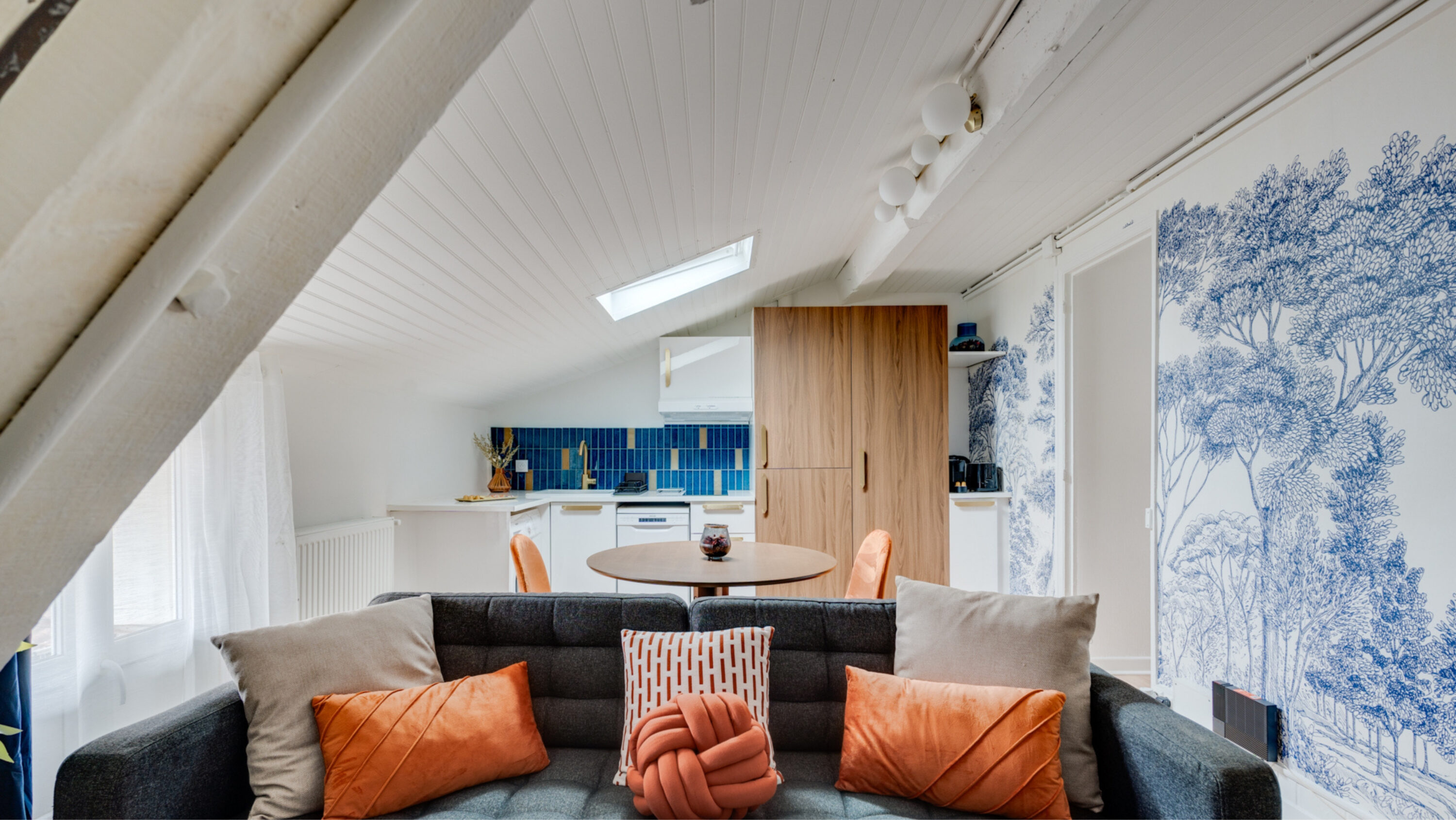 Intérieur moderne avec canapé et cuisine ouverte.