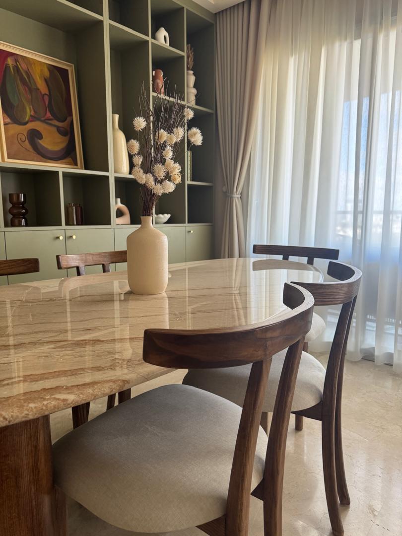 Table à manger moderne, chaises en bois, vase avec fleurs, décoration intérieure élégante.